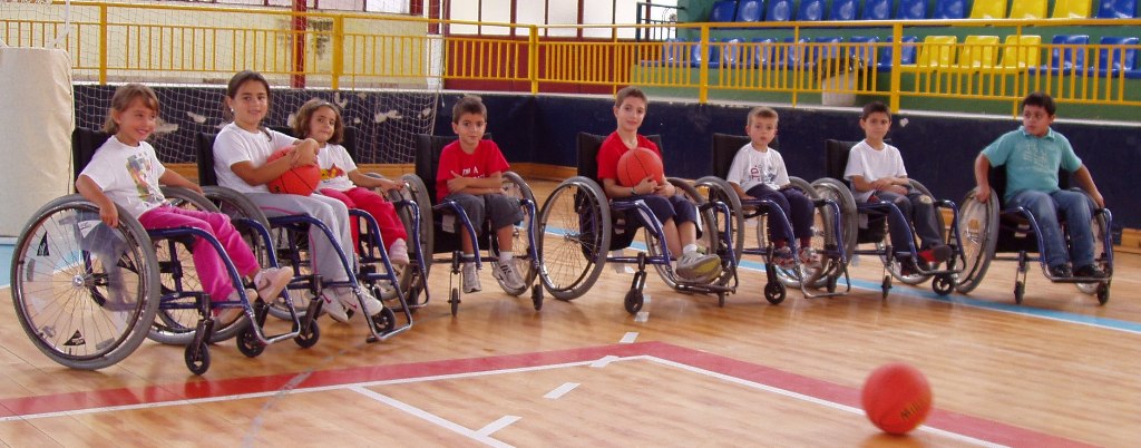 Jóvenes deportistas posando con sus sillas de ruedas